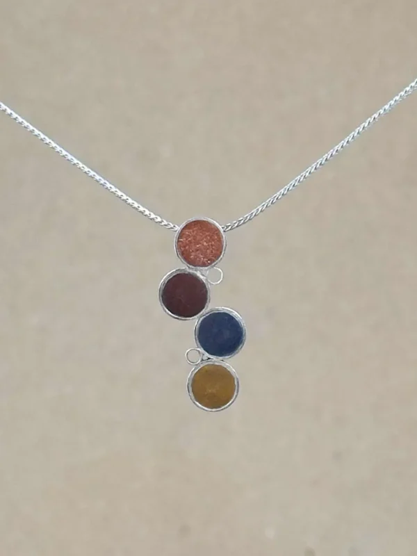 Sterling silver Cascade Pendant with four offset circles of metallic hand-tinted clay in terracotta, burgundy, slate gray, and ochre, on an adjustable silver foxtail chain.