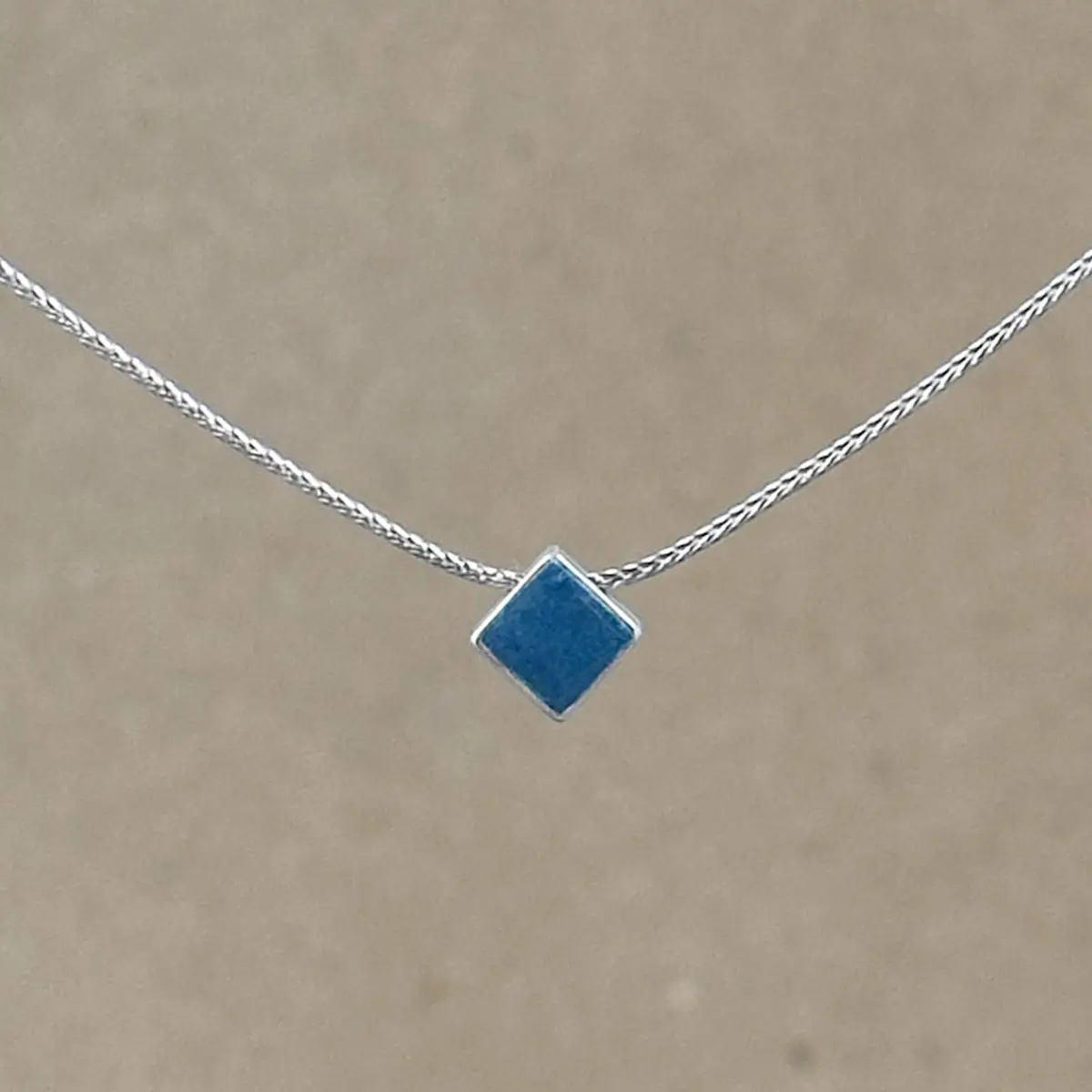 Teal Point necklace — small diamond-shaped teal clay pendant in a sterling silver frame on a fine foxtail chain.