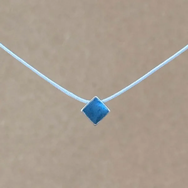 Teal Point necklace — small diamond-shaped teal clay pendant in a sterling silver frame on a light gray kumihimo cord.