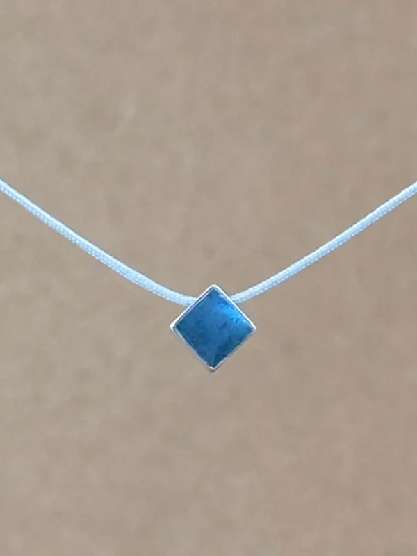 Teal Point necklace — small diamond-shaped teal clay pendant in a sterling silver frame on a light gray kumihimo cord.