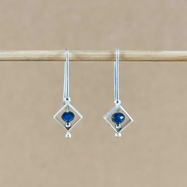 Pair of Lapis Frame Earrings hanging side by side, with diamond-shaped sterling silver frames and lapis lazuli beads centered inside.