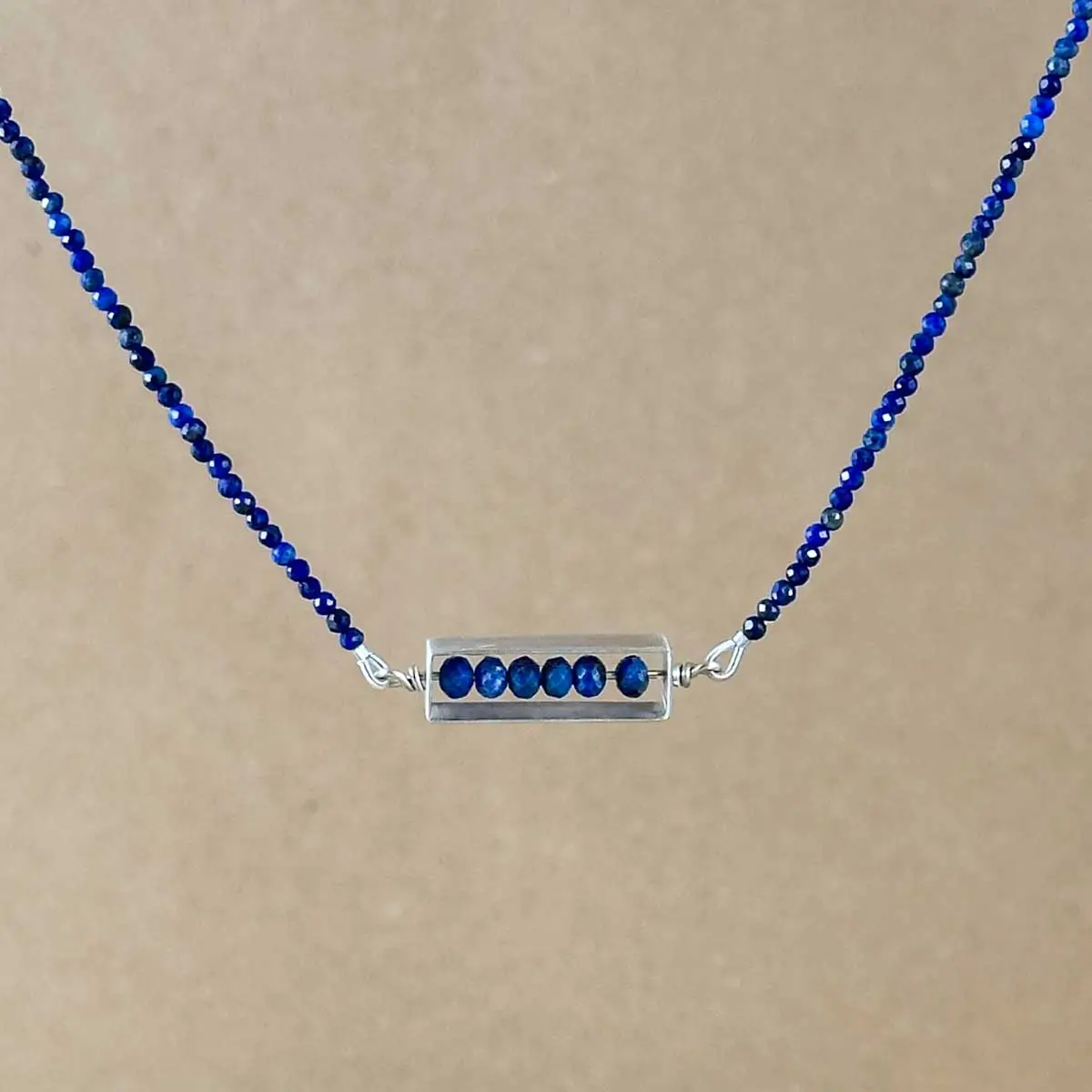 Brushed sterling silver frame pendant strung with faceted lapis lazuli beads on a lapis lazuli beaded chain.